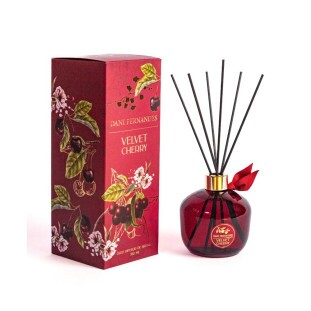 Óleo Difusor de Aromas Velvet Cherry Dani Fernandes 350ml com frasco vermelho elegante e varetas de madeira para perfumar ambientes ao lado de sua embalagem