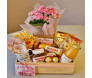 cesta de madeira com itens de café da manhã e com arranjo de flores kalandiva