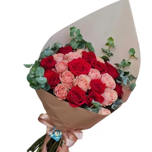 Buquê de 24 rosas Rosely em tons de vermelho e rosa com folhagens de eucalipto, embalado em papel marrom e amarrado com fita de cetim
