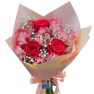 Buquê com 3 rosas vermelhas, astromélias rosas e gipsofila em papel rosado com laço de cetim.