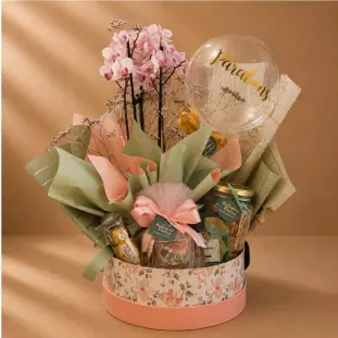 Cesta Parabéns com mini orquídea, balão bubble, Ferrero Rocher, café, biscoitos e caneca em box floral