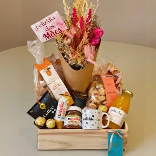 cesta repleta de produtos de café da manhã com buquê de flores secas no centro
