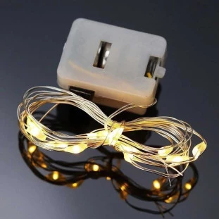 Luzes de LED douradas em fios finos seguradas em mãos, iluminando com um brilho suave