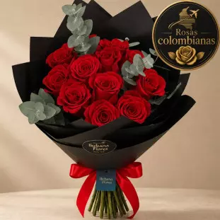 Buquê Rubi com rosas vermelhas premium, ramos de eucalipto e embalagem de papel fosco preto com laço de cetim vermelho e etiqueta oval da Ikebana Flores BH.