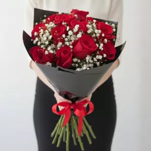 Buquê com 12 rosas colombianas vermelhas e gipsofila embalado em papel preto com laço preto