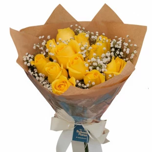 Buquê com 12 rosas amarelas e gipsofila embalado em papel kraft com laço branco da Ikebana Flores, presente com entrega rápida em Belo Horizonte.