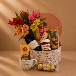 Cesta de café da manhã com astromélias coloridas, chocolates, café, biscoitos, suco de uva e caneca gratidão