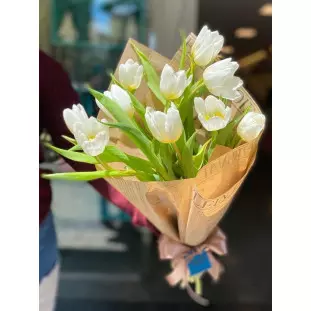 buquê de tulipa branca em uma embalagem que imita jornal