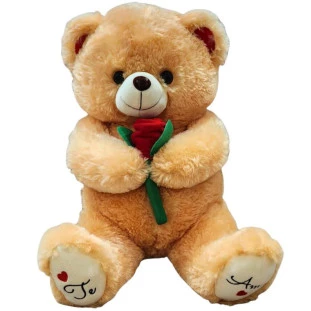 Urso de pelúcia grande segurando rosa vermelha com inscrição "Te Amo" nos pés