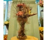 Arranjo de flores secas em vaso de vidro com borboleta decorativa
