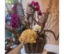 Arranjo de orquídeas roxas e flores secas com ursinho de pelúcia em cachepot de madeira, perfeito para decoração ou presente