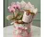 Box de presente cilíndrica com estampa floral contendo orquídea Phalaenopsis rosa, lata de biscoitos Delicê e laços de fita de cetim rosa seco.