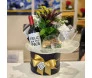 Caixa de presente para o Dia dos Pais contendo vinho, taça, amendoins e arranjo de folhas, com decoração festiva
