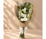 Buquê vertical com flores brancas variadas e folhagens verdes, envolvido em manta telada marrom e finalizado com laço branco