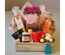 cesta de presente com uma planta de Kalandiva rosa envolta em embalagem plástica, decorada com um laço rosa. Ao lado, há outra parte da cesta envolta em tule rosa, contendo produtos diversos e outro laço rosa com uma etiqueta, simbolizando o carinho e del