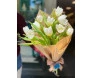 buquê de tulipa branca em uma embalagem que imita jornal